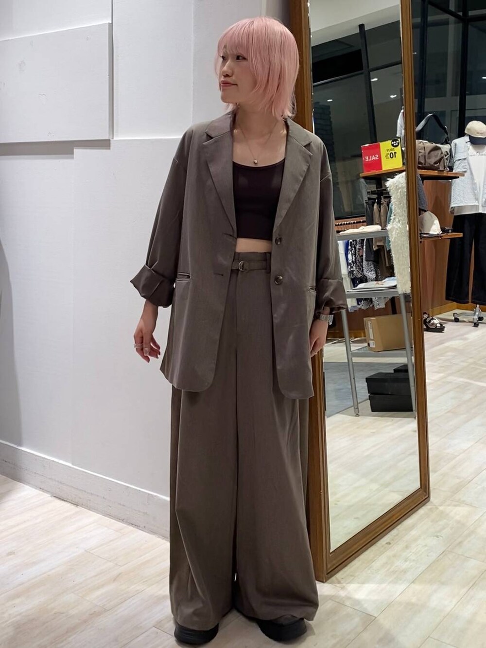 ブラック系のブーツ、ブラウン系のキャミソール、ブラウン系のスラックスを着用したレディースの夏コーディネートの3枚目の写真