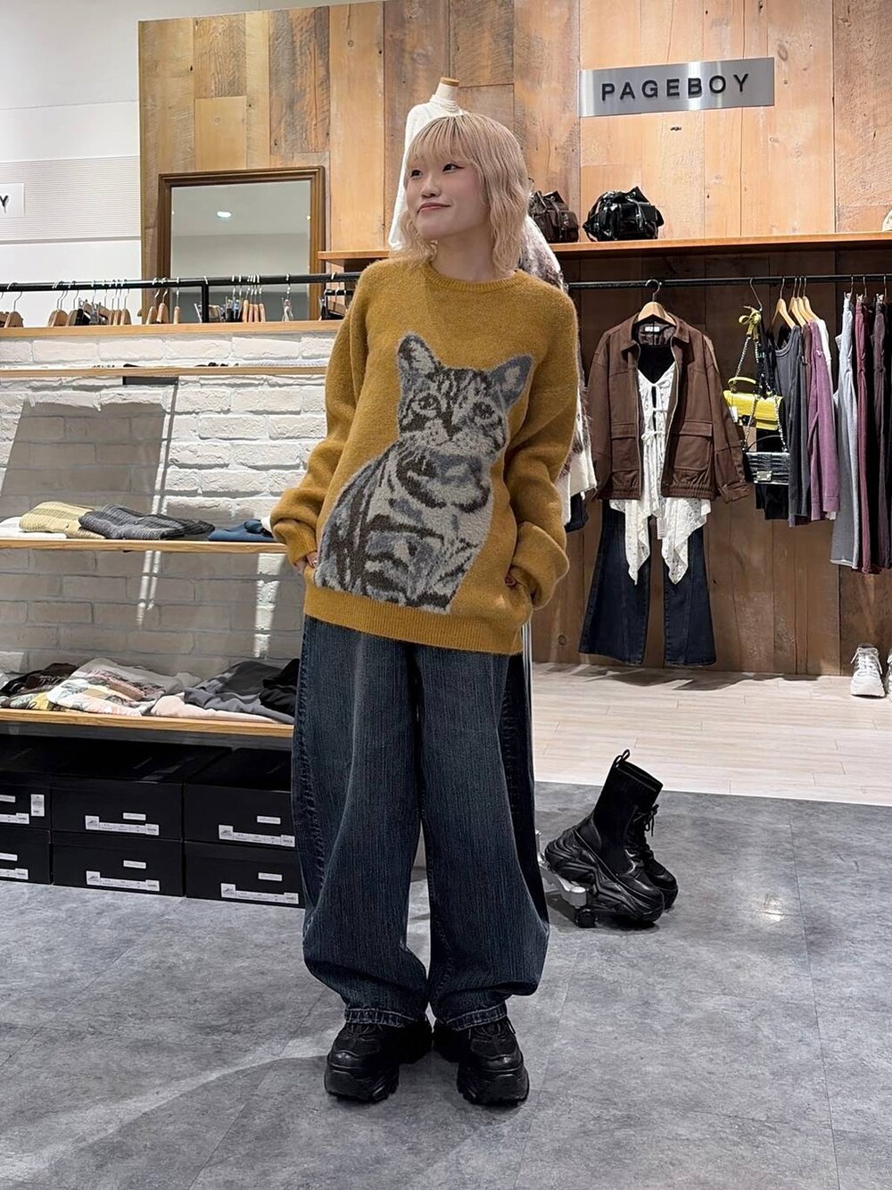 イエロー系のニット/セーター、ブルー系のデニムパンツを着用したレディースの秋コーディネートの5枚目の写真