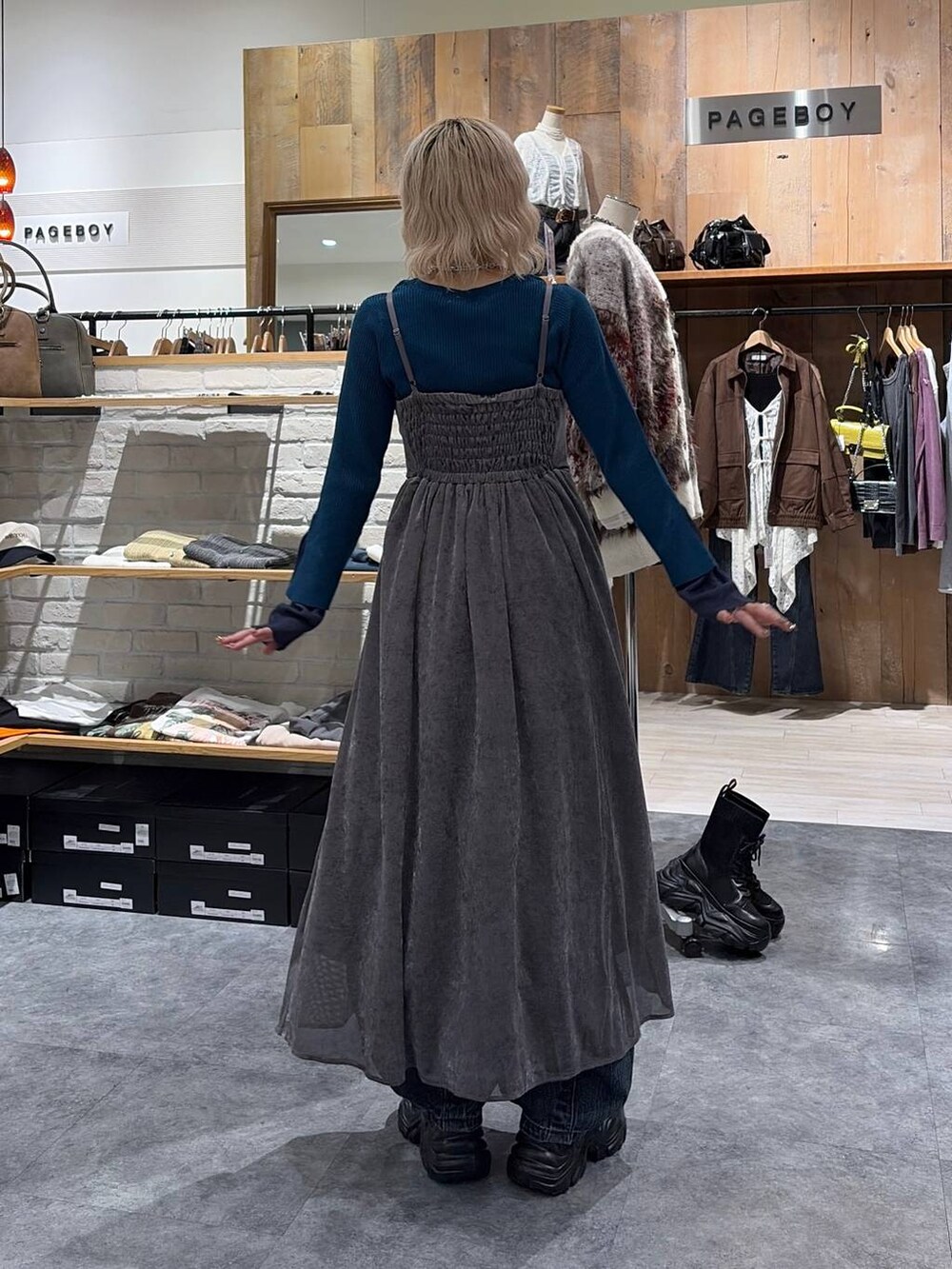 ブラック系のスニーカー、グリーン系のニット/セーター、ブルー系のデニムパンツを着用したレディースの秋コーディネートの2枚目の写真