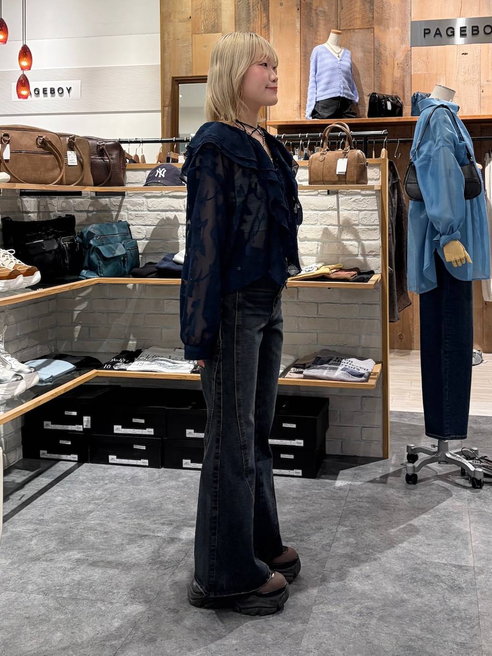 ブラウン系のブーツ、ブルー系のデニムパンツ、イエロー系のトートバッグを着用したレディースの春コーディネートの5枚目の写真