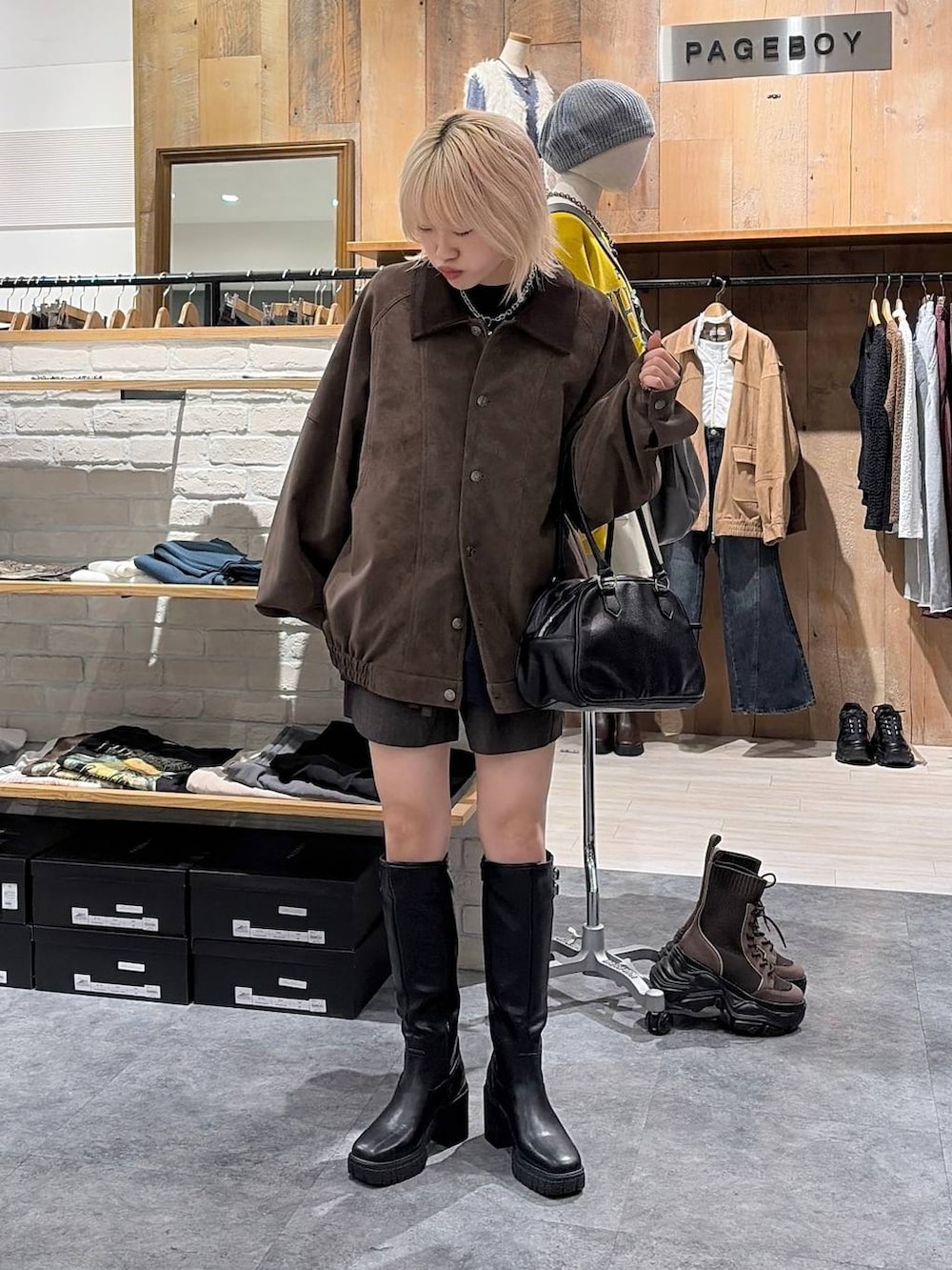ブラック系のブーツ、ブラック系のボストンバッグ、ブラウン系のブルゾンを着用したレディースの秋コーディネートの2枚目の写真