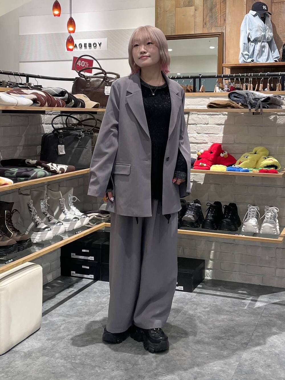 ブラック系のスニーカー、シルバー系のTシャツ/カットソー、グレー系のデニムパンツを着用したレディースの冬コーディネートの2枚目の写真