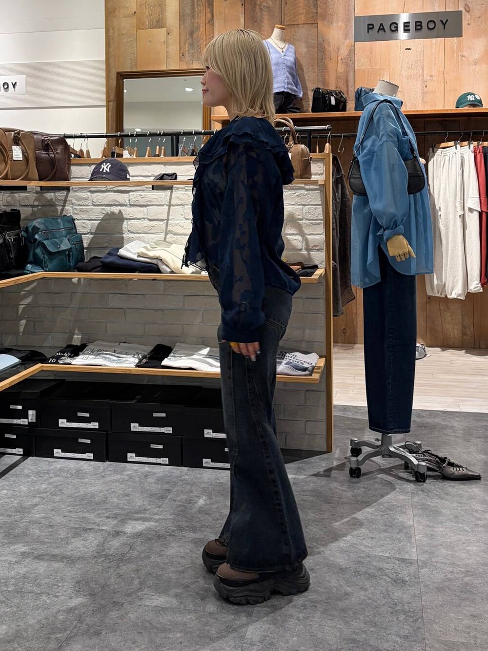 ブラウン系のブーツ、ブルー系のデニムパンツ、イエロー系のトートバッグを着用したレディースの春コーディネートの7枚目の写真