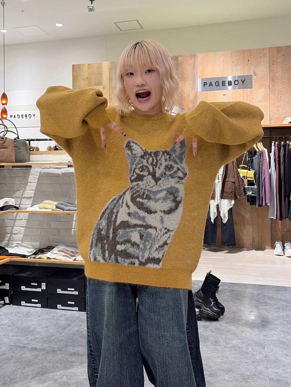 イエロー系のニット/セーター、ブルー系のデニムパンツを着用したレディースの秋コーディネートの6枚目の写真