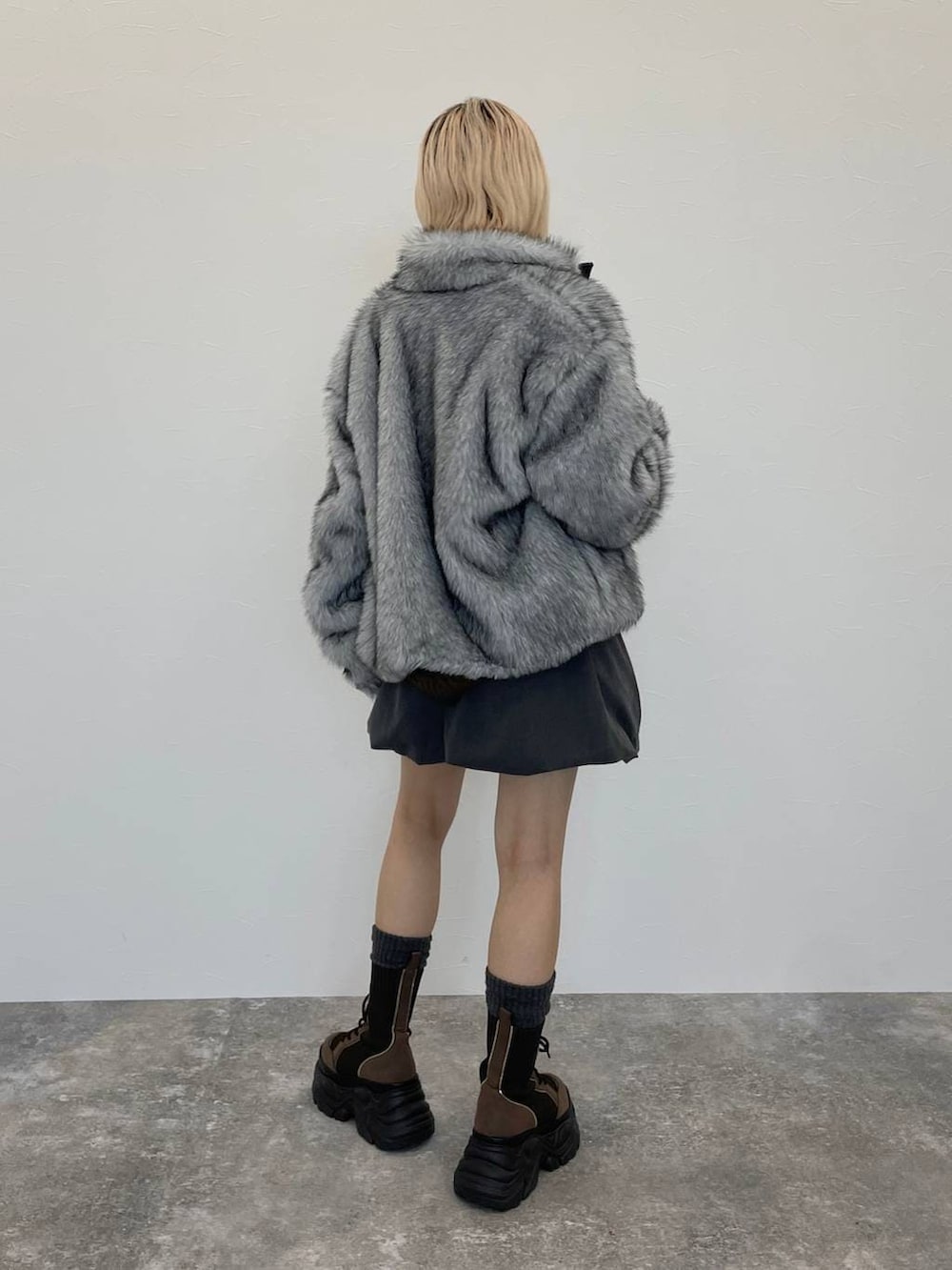 ブラウン系のブーツ、ブラック系のキャミソール、ブラウン系のニット/セーターを着用したレディースの秋コーディネートの3枚目の写真