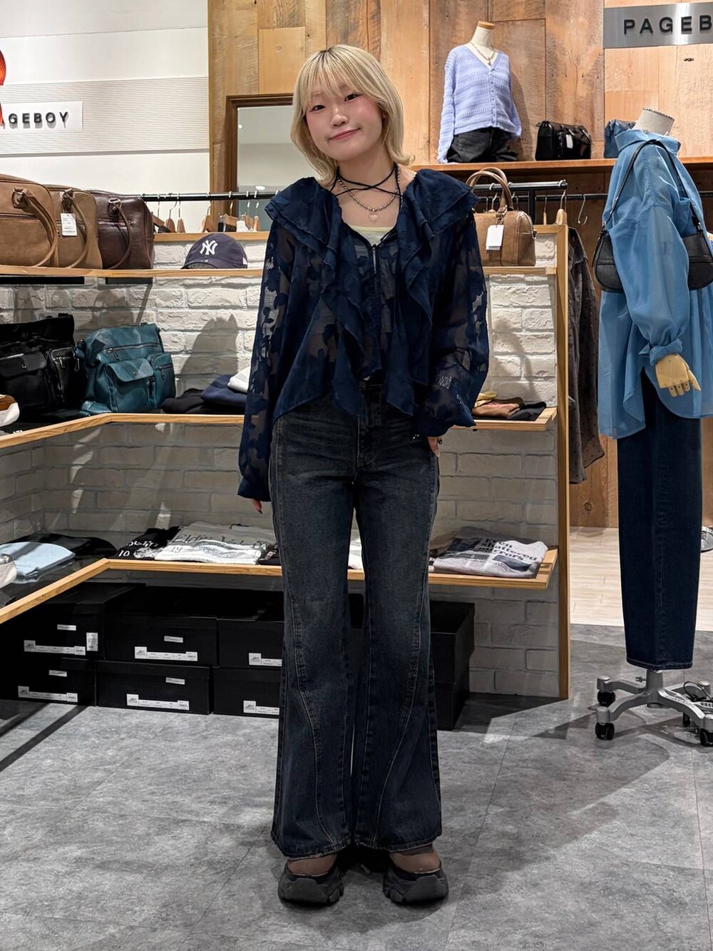 ブラウン系のブーツ、ブルー系のデニムパンツ、イエロー系のトートバッグを着用したレディースの春コーディネートの8枚目の写真