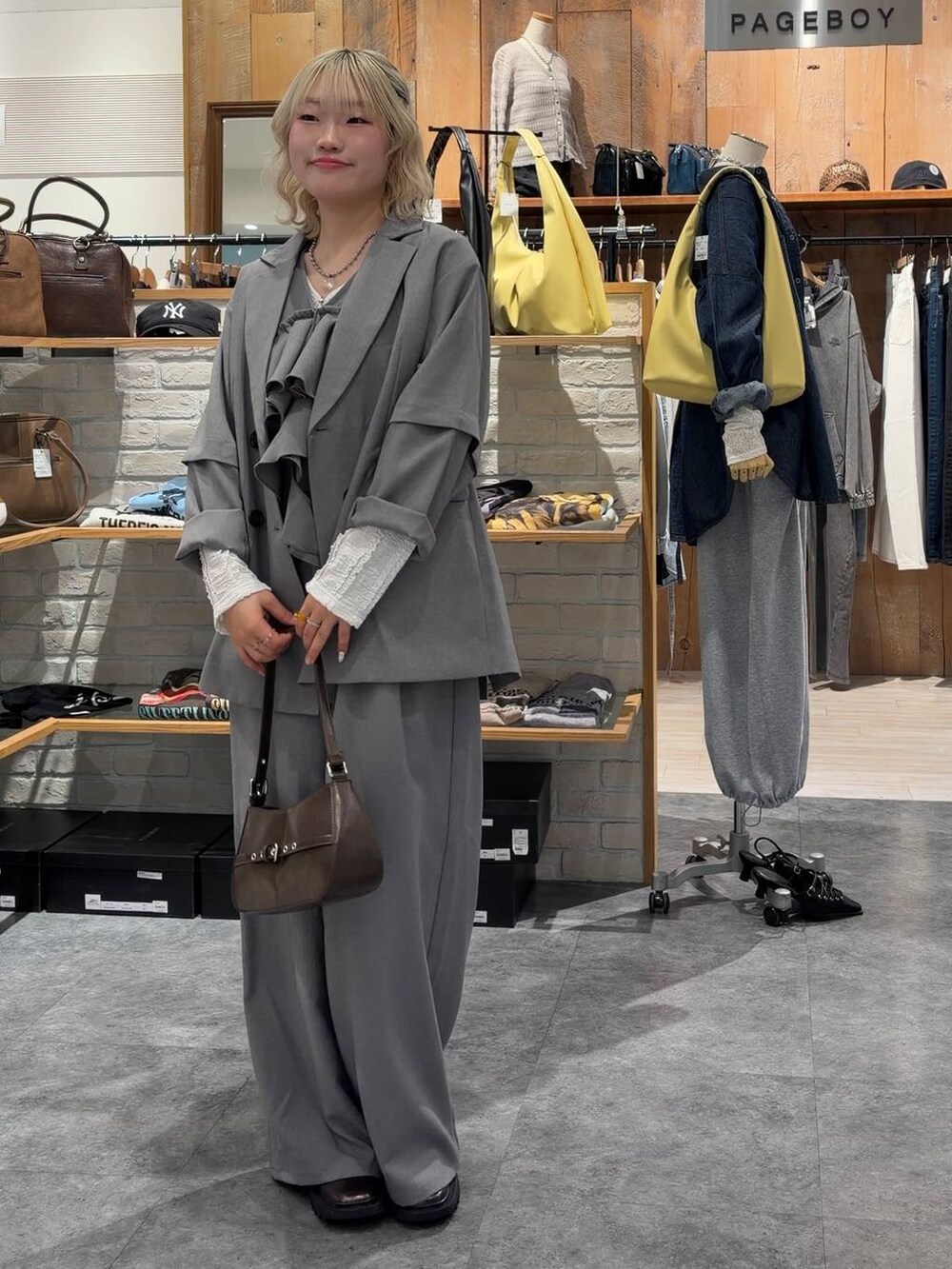 その他のブーツ、ブラウン系のハンドバッグ、グレー系のテーラードジャケットを着用したレディースの春コーディネートの2枚目の写真