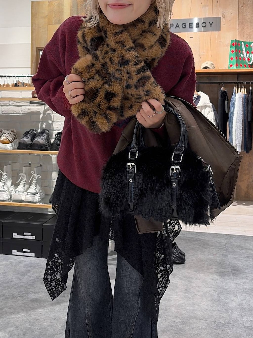 ブラック系のスニーカー、ブルー系のデニムパンツ、ブラック系のチュニックを着用したレディースの冬コーディネートの4枚目の写真