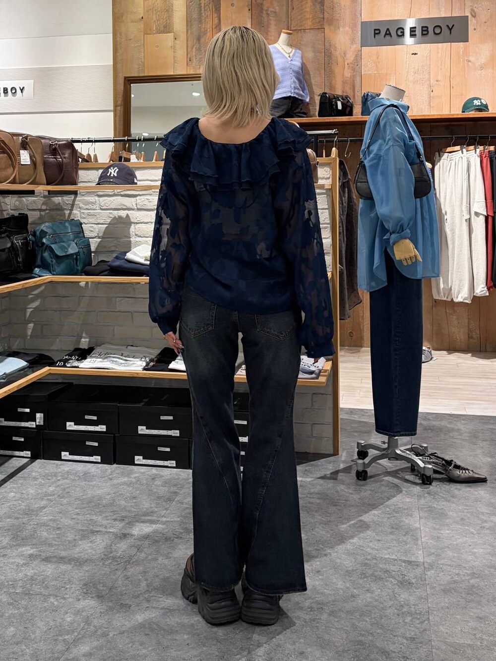 ブラウン系のブーツ、ブルー系のデニムパンツ、イエロー系のトートバッグを着用したレディースの春コーディネートの6枚目の写真