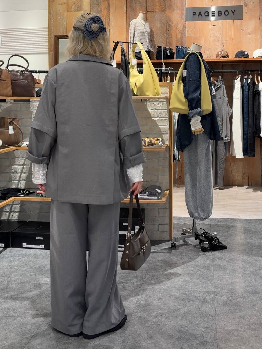 その他のブーツ、ブラウン系のハンドバッグ、グレー系のテーラードジャケットを着用したレディースの春コーディネートの4枚目の写真