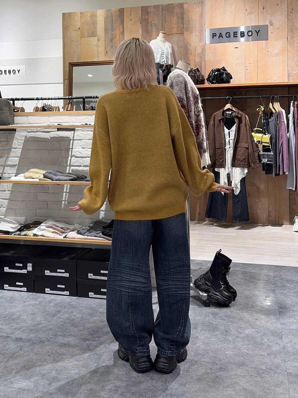 イエロー系のニット/セーター、ブルー系のデニムパンツを着用したレディースの秋コーディネートの3枚目の写真