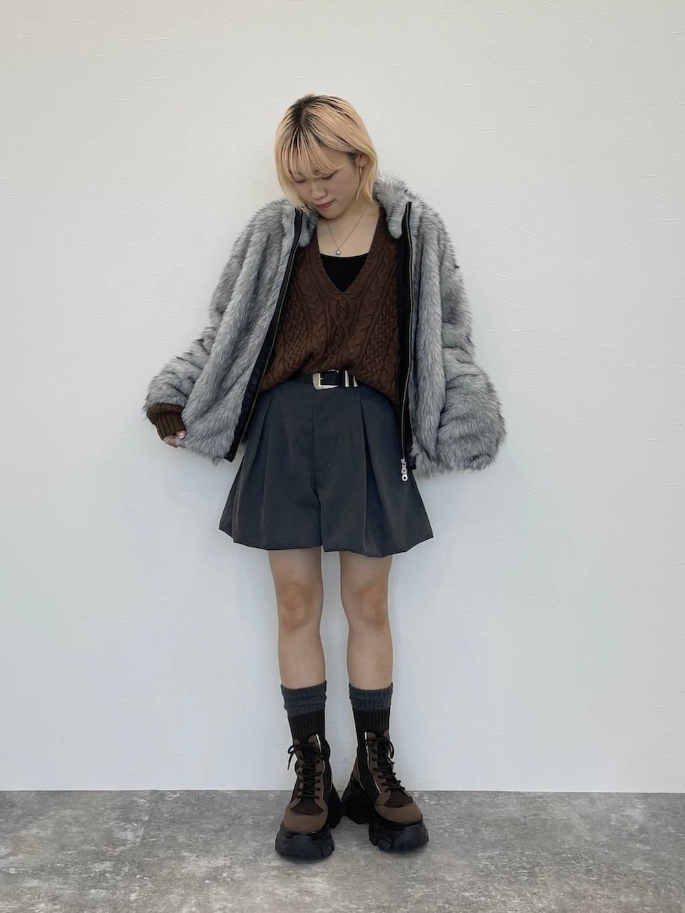 ブラウン系のブーツ、ブラック系のキャミソール、ブラウン系のニット/セーターを着用したレディースの秋コーディネートの4枚目の写真