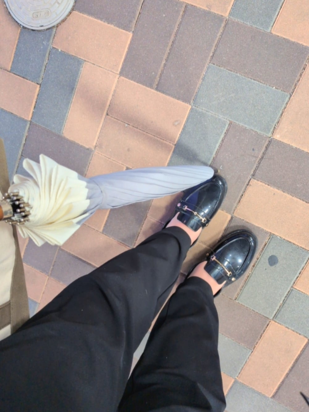 ブラック系のレインシューズ、ブラック系のパンツ、ブラック系のダウンジャケット/コートを着用したレディースの冬コーディネートの2枚目の写真