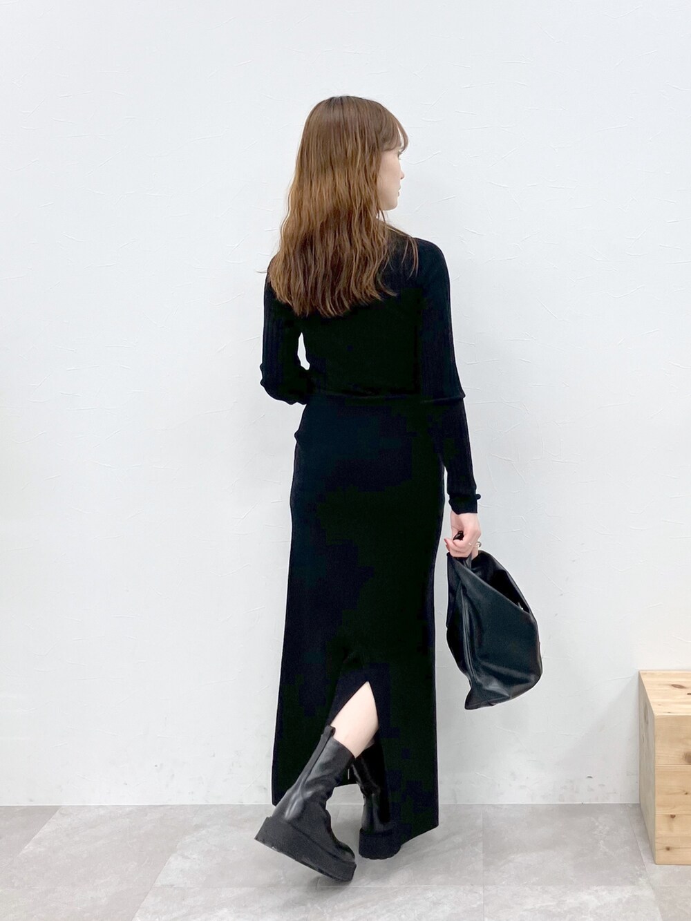 ブラック系のダウンジャケット/コート、ブラック系のニット/セーター、ブラック系のスカートを着用したレディースの秋コーディネートの7枚目の写真