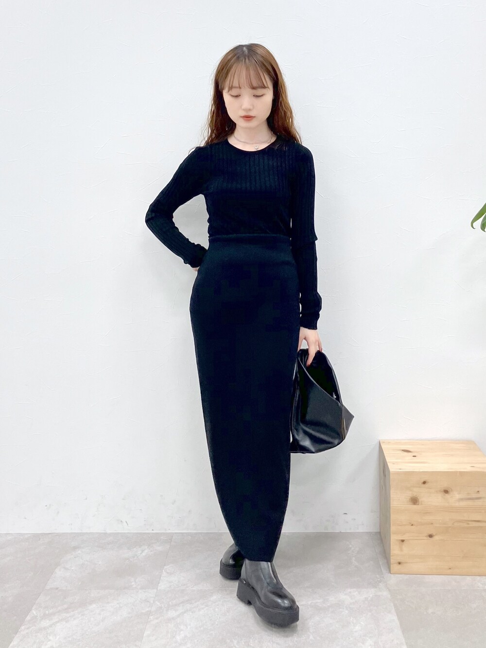 ブラック系のダウンジャケット/コート、ブラック系のニット/セーター、ブラック系のスカートを着用したレディースの秋コーディネートの5枚目の写真