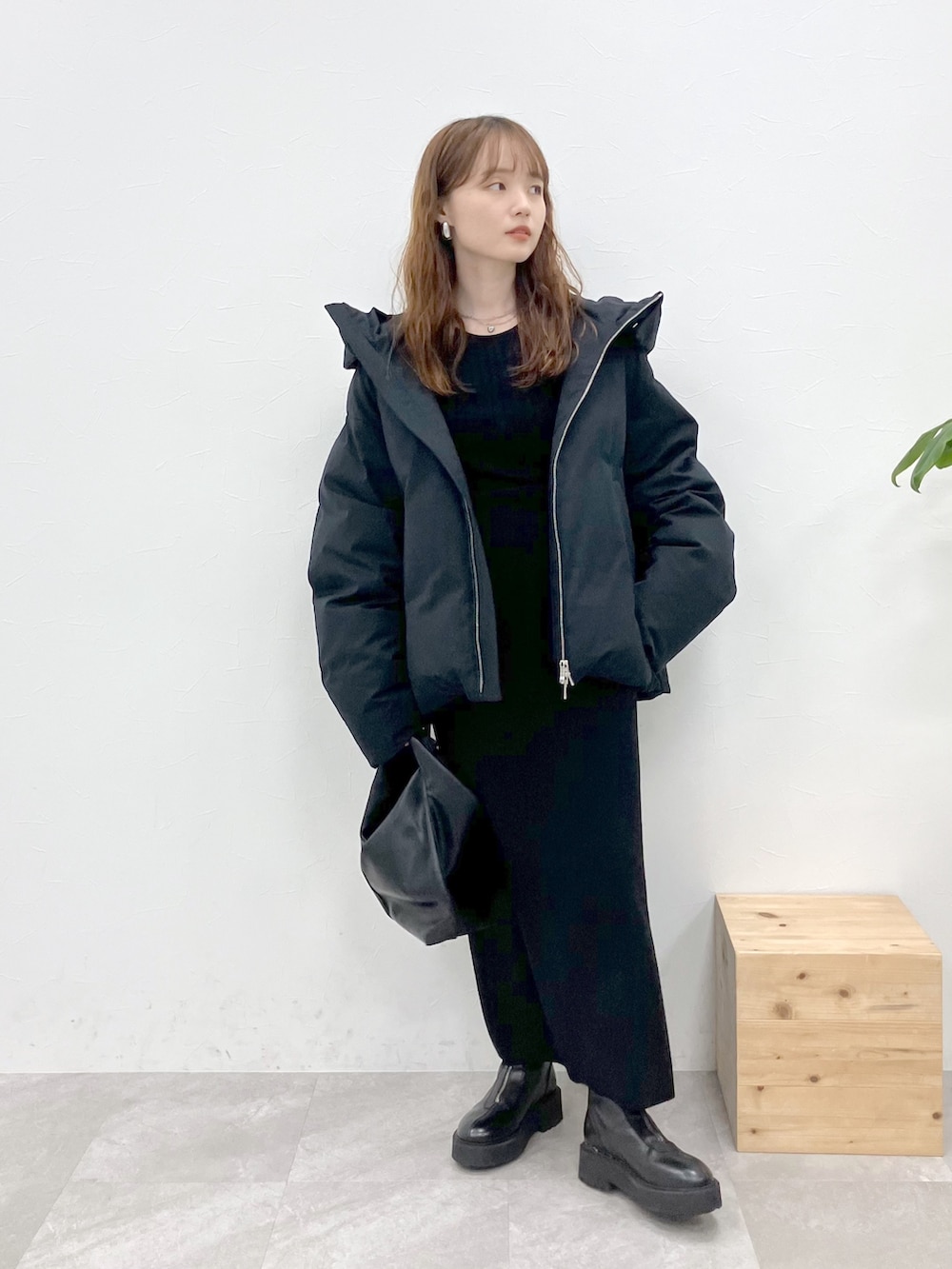 ブラック系のダウンジャケット/コート、ブラック系のニット/セーター、ブラック系のスカートを着用したレディースの秋コーディネートの3枚目の写真