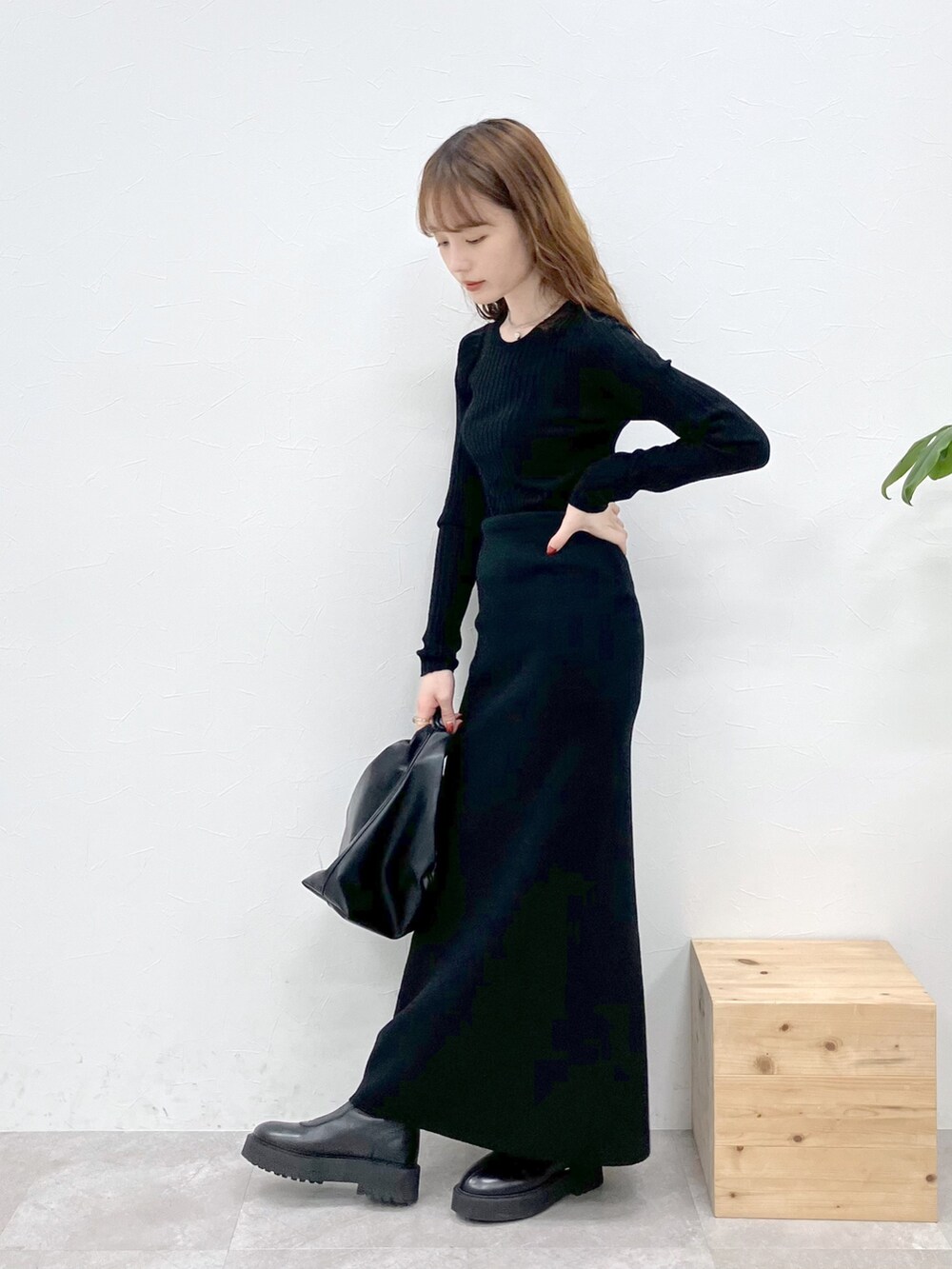 ブラック系のダウンジャケット/コート、ブラック系のニット/セーター、ブラック系のスカートを着用したレディースの秋コーディネートの6枚目の写真