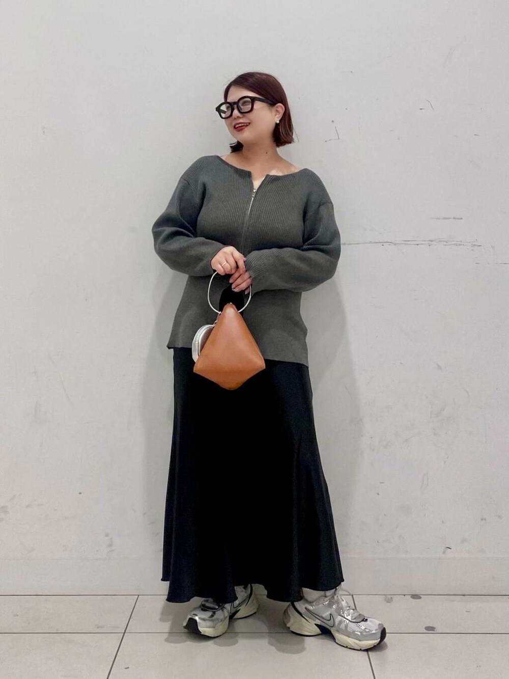 イエロー系のハンドバッグ、ブラック系のスカート、グレー系のカーディガン/ボレロを着用したレディースの春コーディネートの5枚目の写真