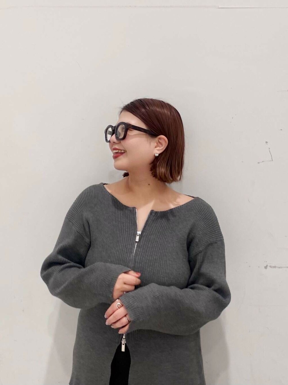 イエロー系のハンドバッグ、ブラック系のスカート、グレー系のカーディガン/ボレロを着用したレディースの春コーディネートの4枚目の写真