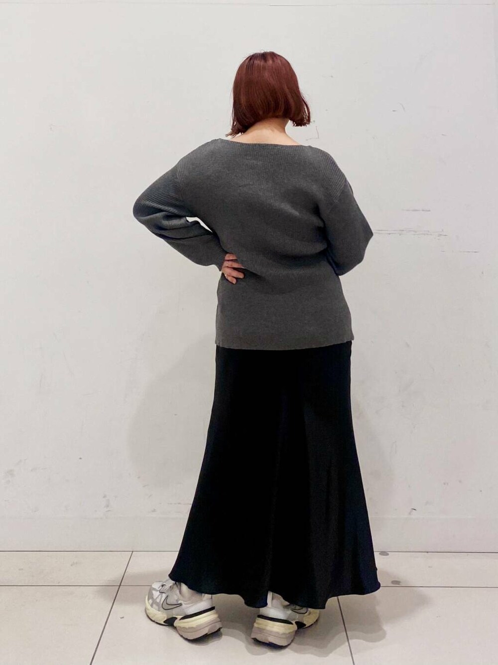 イエロー系のハンドバッグ、ブラック系のスカート、グレー系のカーディガン/ボレロを着用したレディースの春コーディネートの3枚目の写真