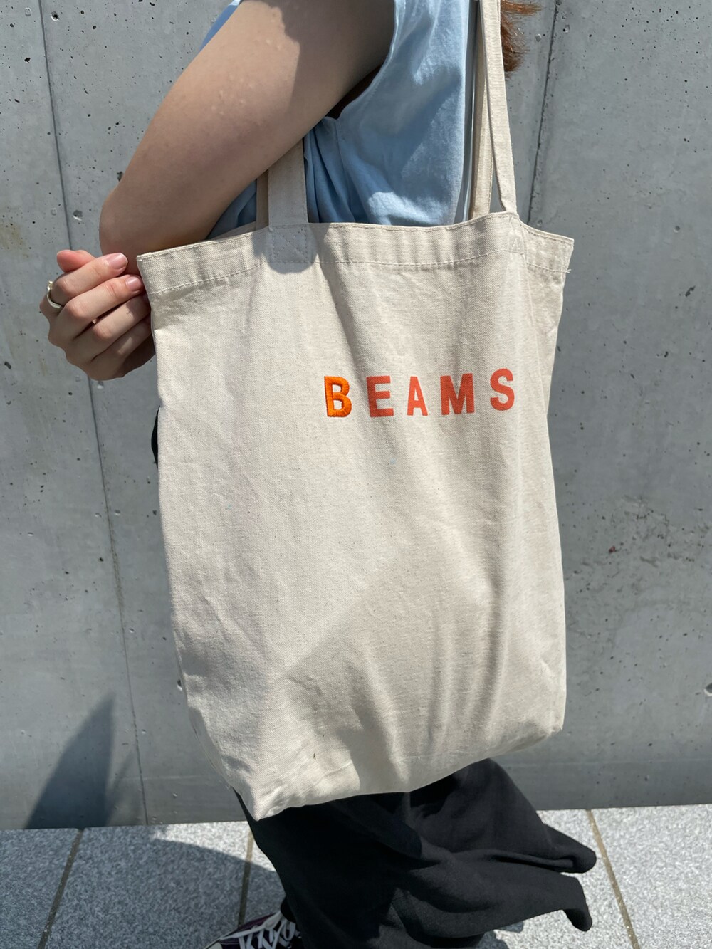 パープル系のスニーカー、ブルー系のTシャツ/カットソー、ブラック系のスカートを着用したレディースの夏コーディネートの4枚目の写真