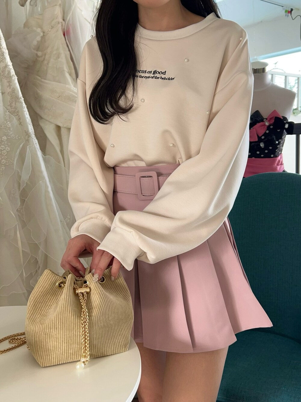 ピンク系のスカート、ベージュ系のショルダーバッグを着用したレディースの冬コーディネートの3枚目の写真