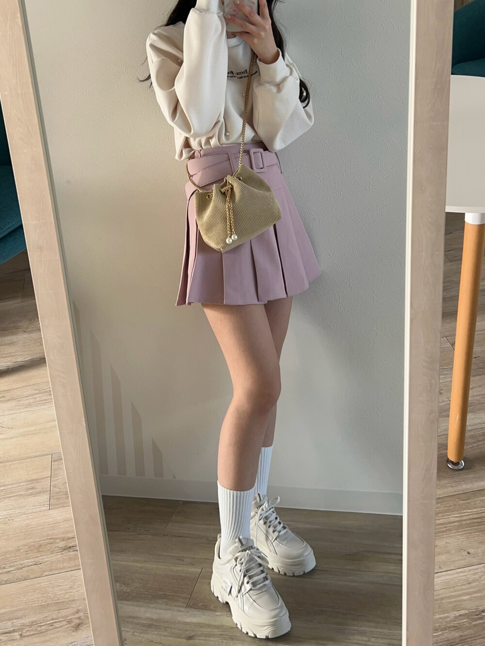 ピンク系のスカート、ベージュ系のショルダーバッグを着用したレディースの冬コーディネートの2枚目の写真