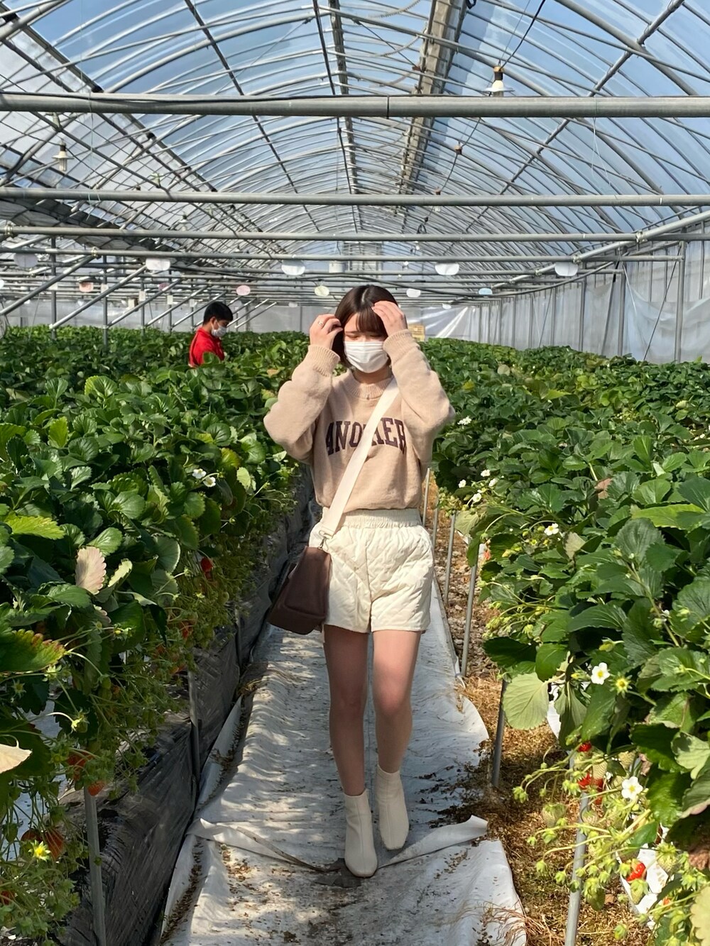 ホワイト系のパンツ、ベージュ系のニット/セーター、ホワイト系のブーツを着用したレディースの春コーディネートの2枚目の写真