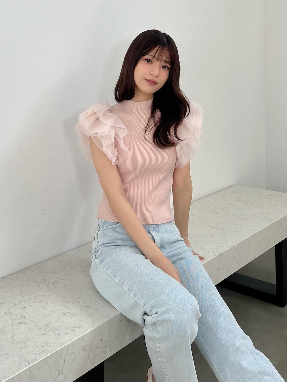 ピンク系のニット/セーター、ブルー系のデニムパンツ、その他のサンダルを着用したレディースの春コーディネートの2枚目の写真