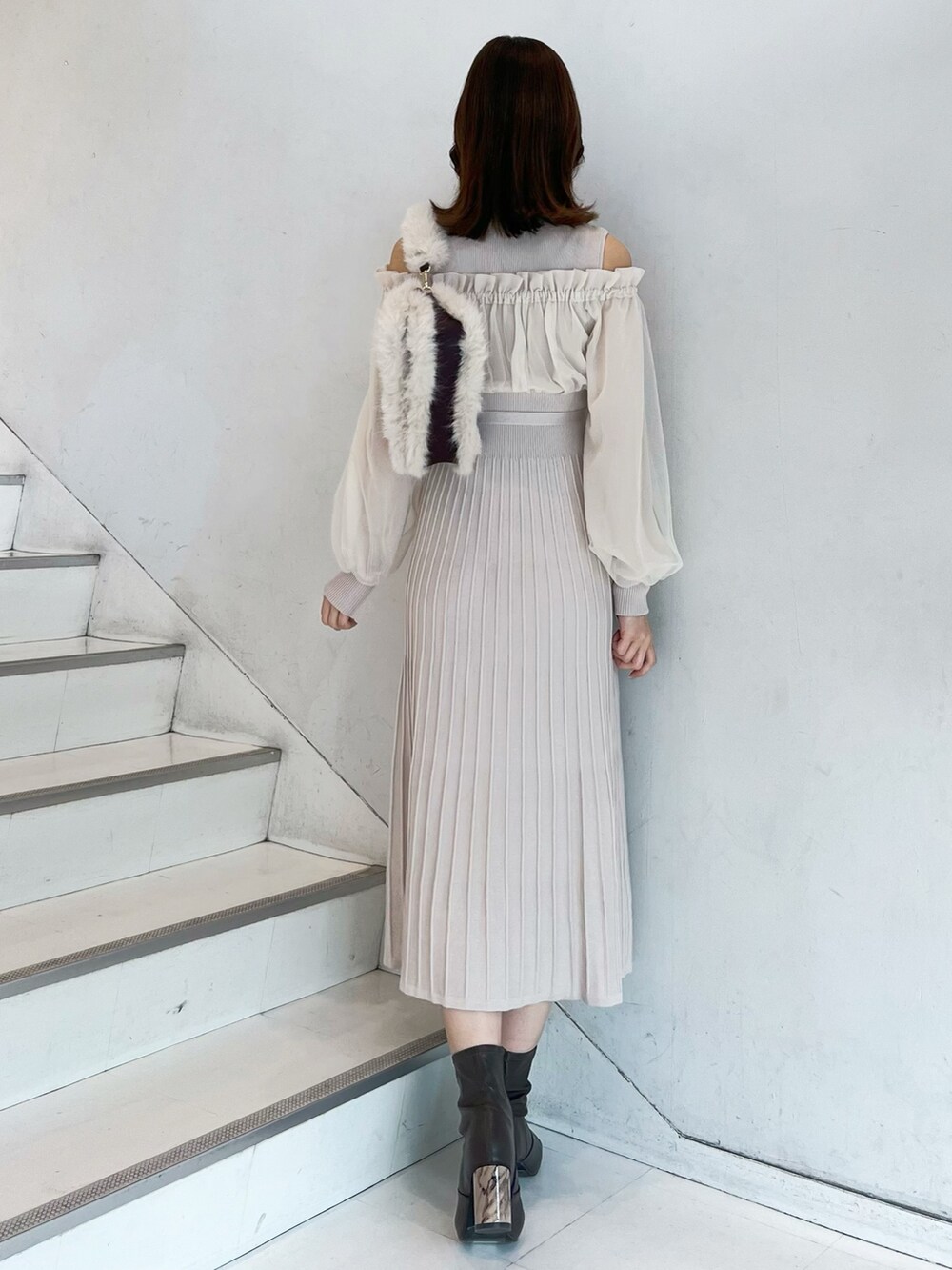 ホワイト系のワンピース、ブラウン系のショルダーバッグ、ブラウン系のブーツを着用したレディースの秋コーディネートの5枚目の写真