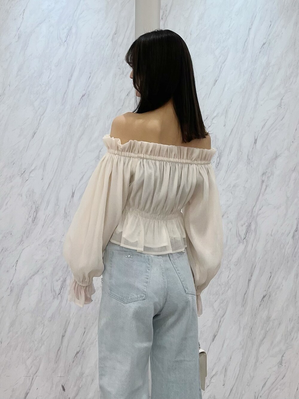 ホワイト系のシャツ/ブラウス、ブルー系のデニムパンツ、ホワイト系のパンプスを着用したレディースの冬コーディネートの4枚目の写真