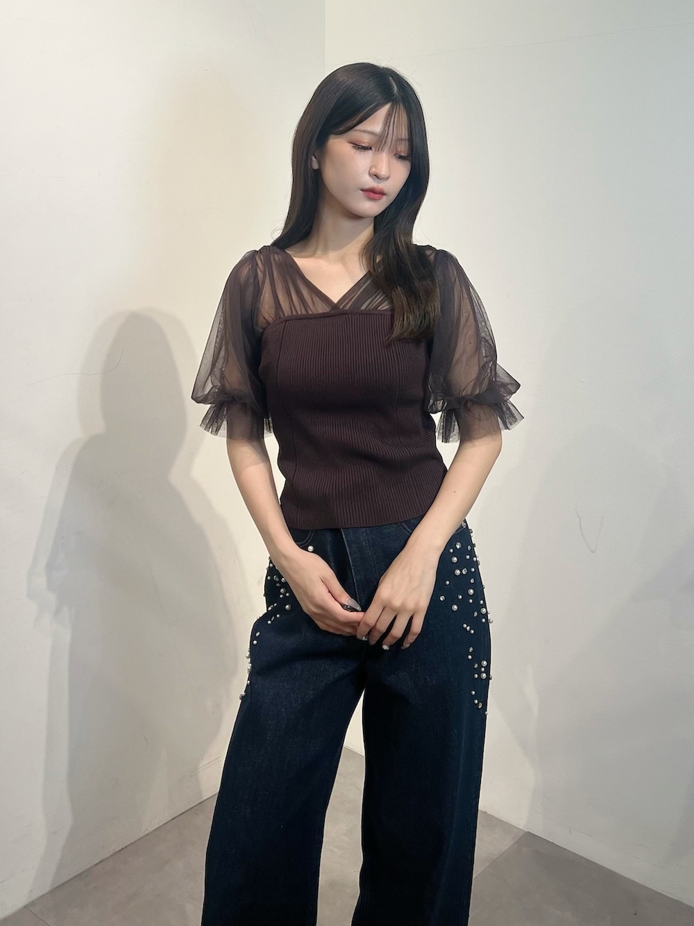 ブラウン系のニット/セーター、ブルー系のデニムパンツを着用したレディースの夏コーディネートの2枚目の写真