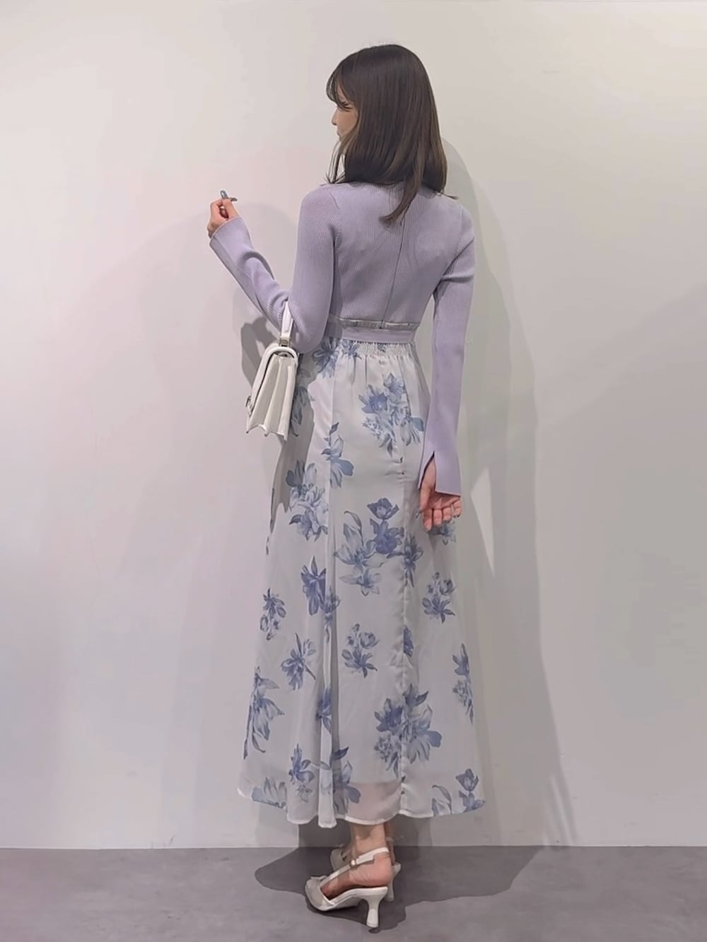 パープル系のワンピース、ブラウン系のブーツ、ホワイト系のハンドバッグを着用したレディースの秋コーディネートの9枚目の写真