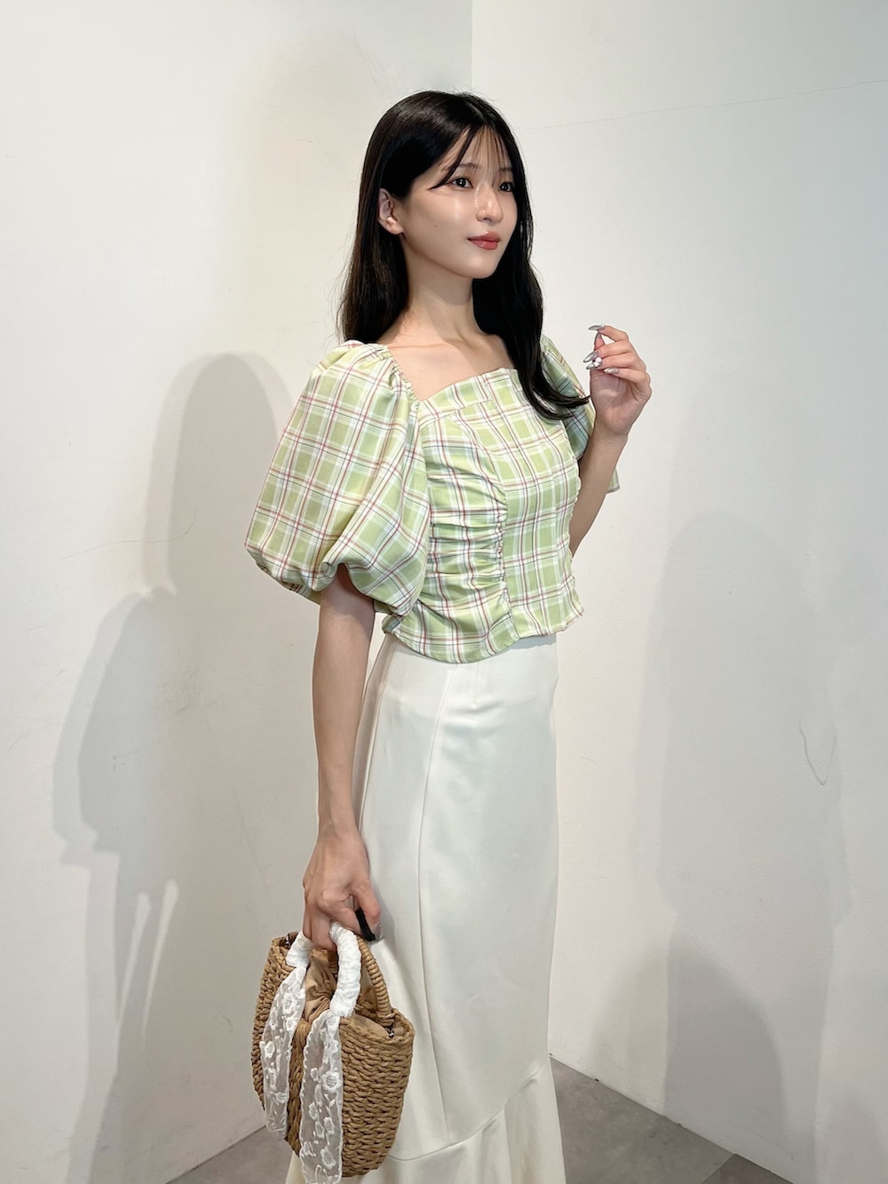 グリーン系のシャツ/ブラウス、ホワイト系のスカート、ホワイト系のサンダルを着用したレディースの夏コーディネートの2枚目の写真