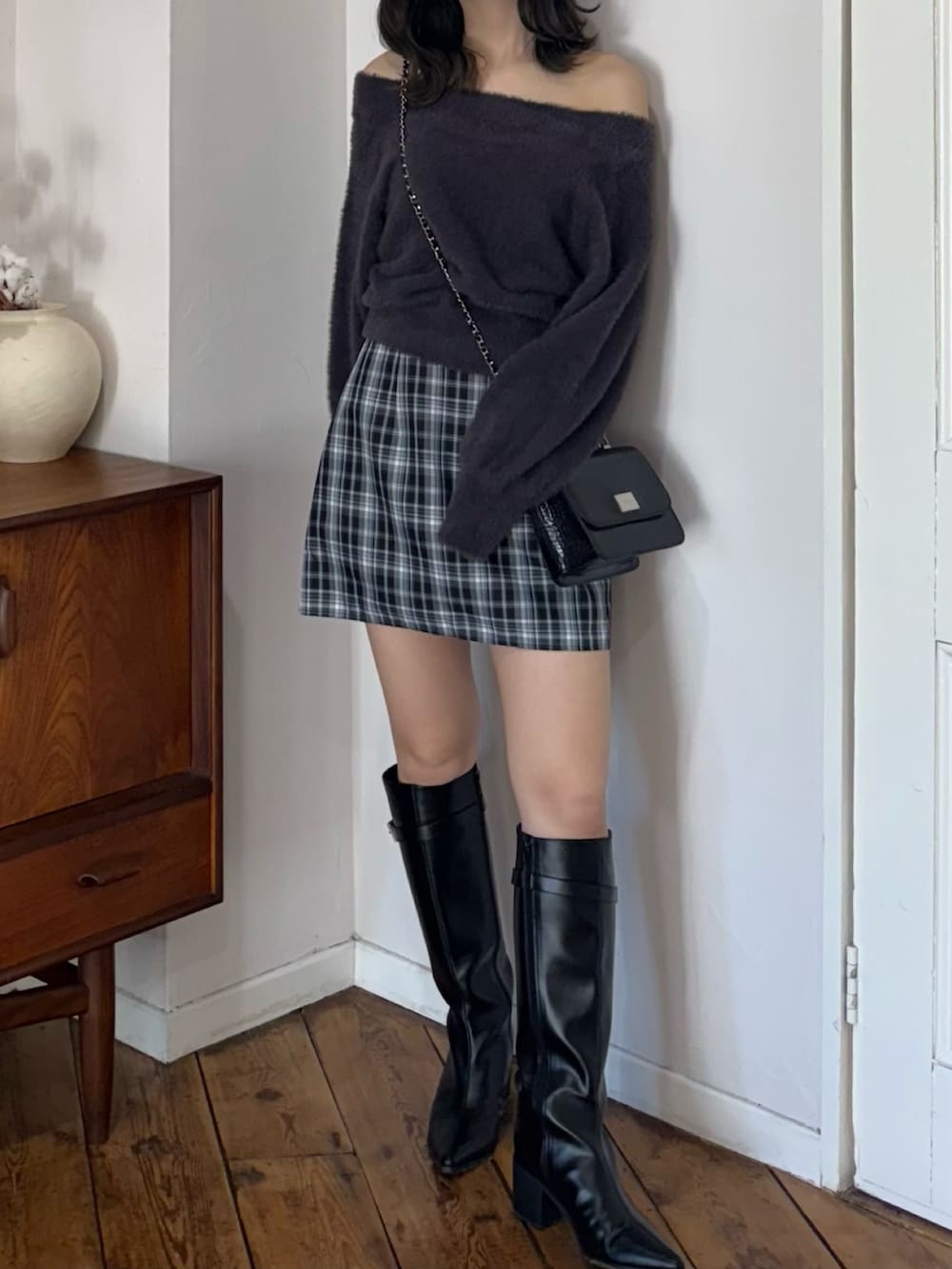 グレー系のニット/セーター、グリーン系のスカート、ブラック系のハンドバッグを着用したレディースの秋コーディネートの2枚目の写真