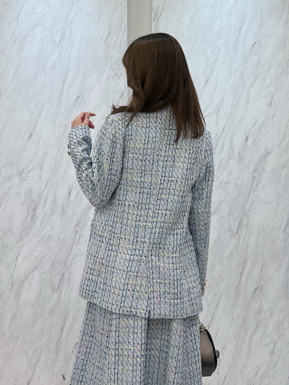 ブルー系のテーラードジャケット、ブルー系のワンピース、ブラウン系のハンドバッグを着用したレディースの冬コーディネートの4枚目の写真