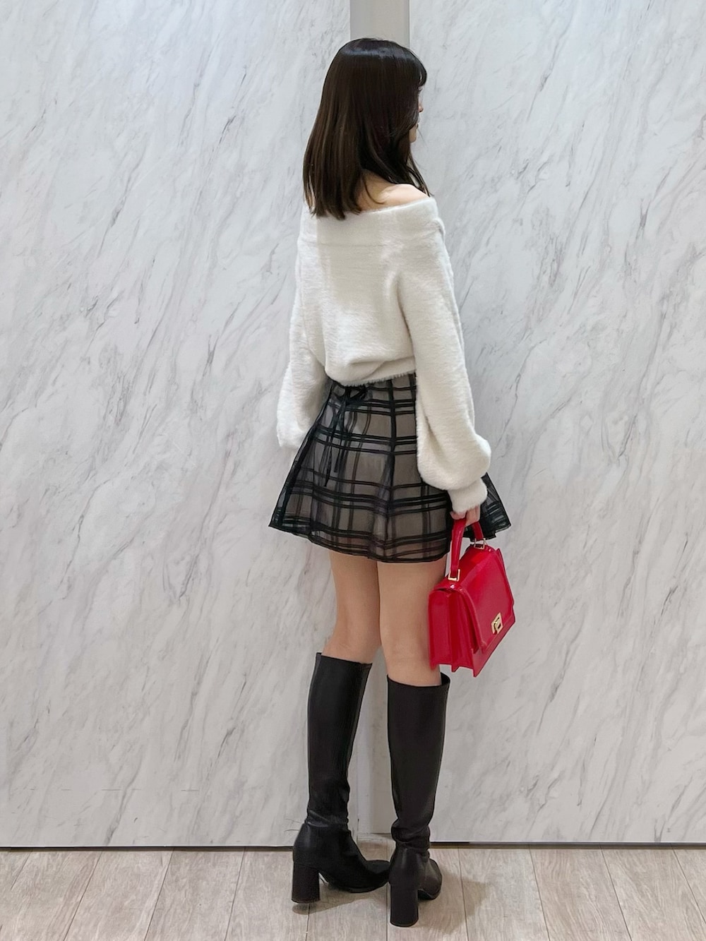 ホワイト系のニット/セーター、ブラック系のその他パンツ、レッド系のハンドバッグを着用したレディースの冬コーディネートの3枚目の写真