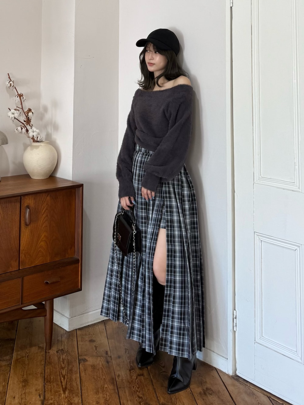 グレー系のニット/セーター、グリーン系のスカート、ブラック系のハンドバッグを着用したレディースの秋コーディネートの7枚目の写真