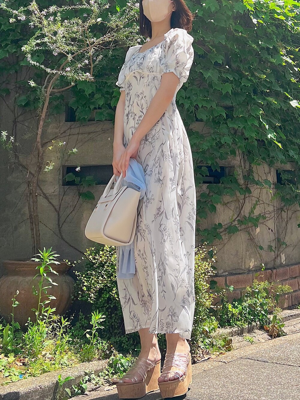 ホワイト系のワンピース、ブルー系のカーディガン/ボレロ、その他のサンダルを着用したレディースの春コーディネートの3枚目の写真