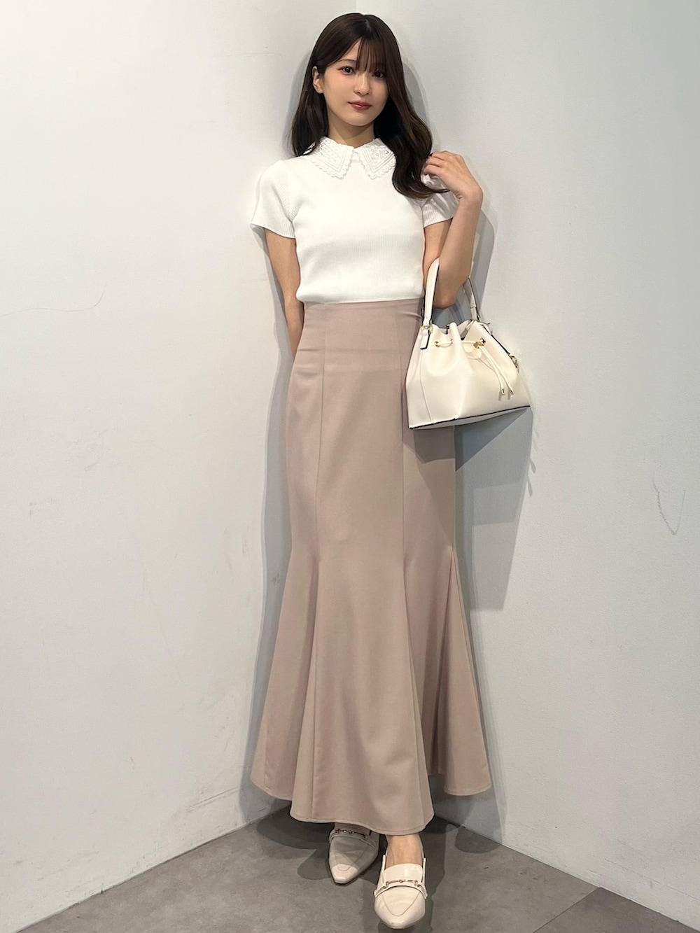 ホワイト系のニット/セーター、ピンク系のスカート、ホワイト系のパンプスを着用したレディースの春コーディネートの4枚目の写真