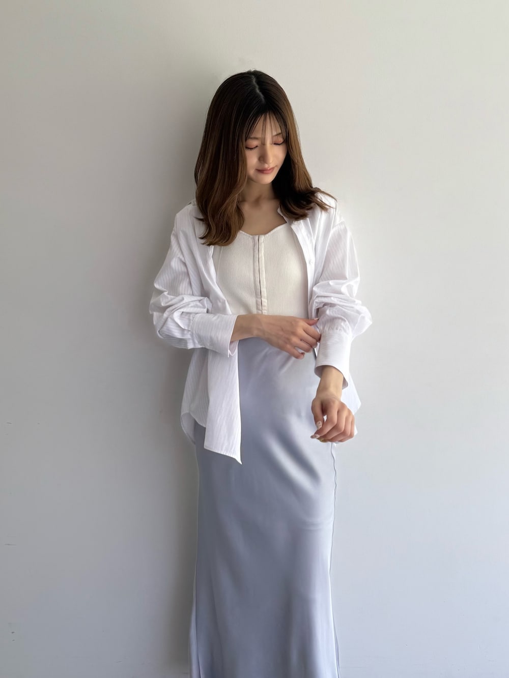 グレー系のスカート、ホワイト系のシャツ/ブラウス、ホワイト系のニット/セーターを着用したレディースの夏コーディネートの2枚目の写真