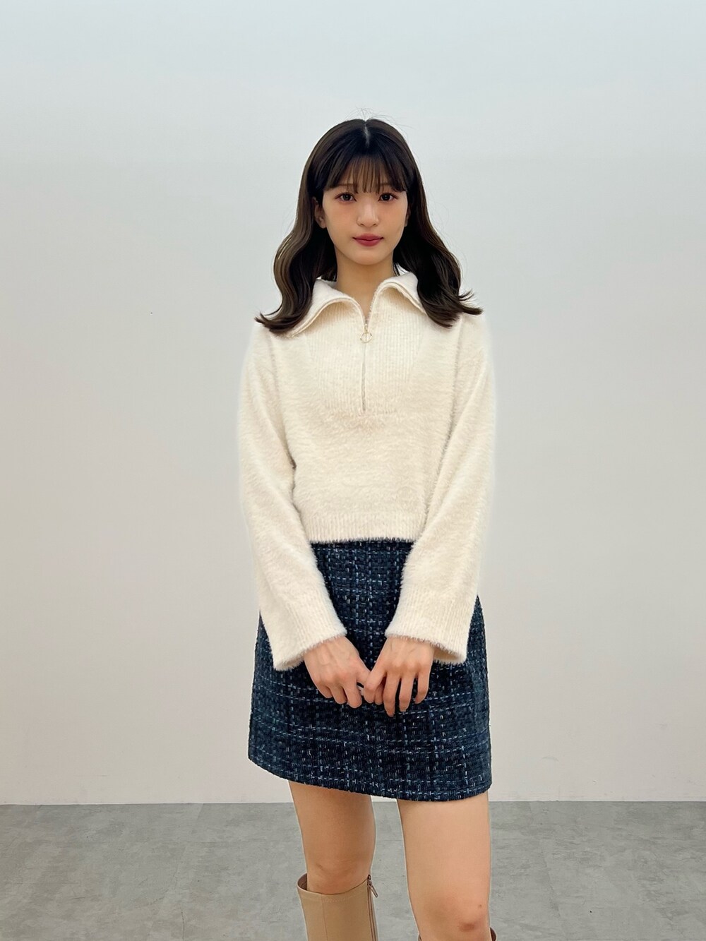 ホワイト系のニット/セーター、ブラック系のスカート、ベージュ系のブーツを着用したレディースの秋コーディネートの8枚目の写真