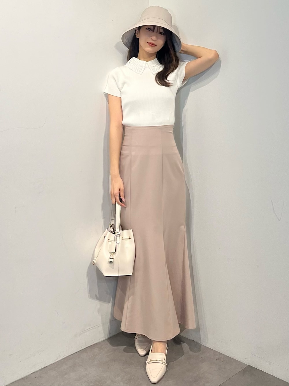 ホワイト系のニット/セーター、ピンク系のスカート、ホワイト系のパンプスを着用したレディースの春コーディネートの7枚目の写真