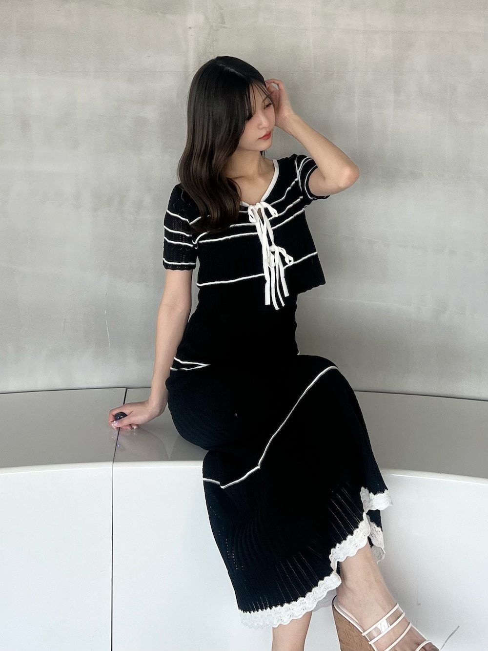 ブラック系のワンピースを着用したレディースの春コーディネートの2枚目の写真