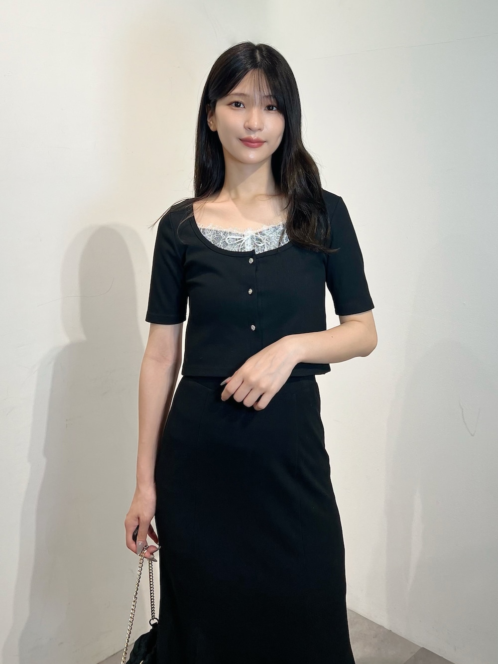ブラック系のカーディガン/ボレロ、ブラック系のスカート、シルバー系のサンダルを着用したレディースの夏コーディネートの3枚目の写真