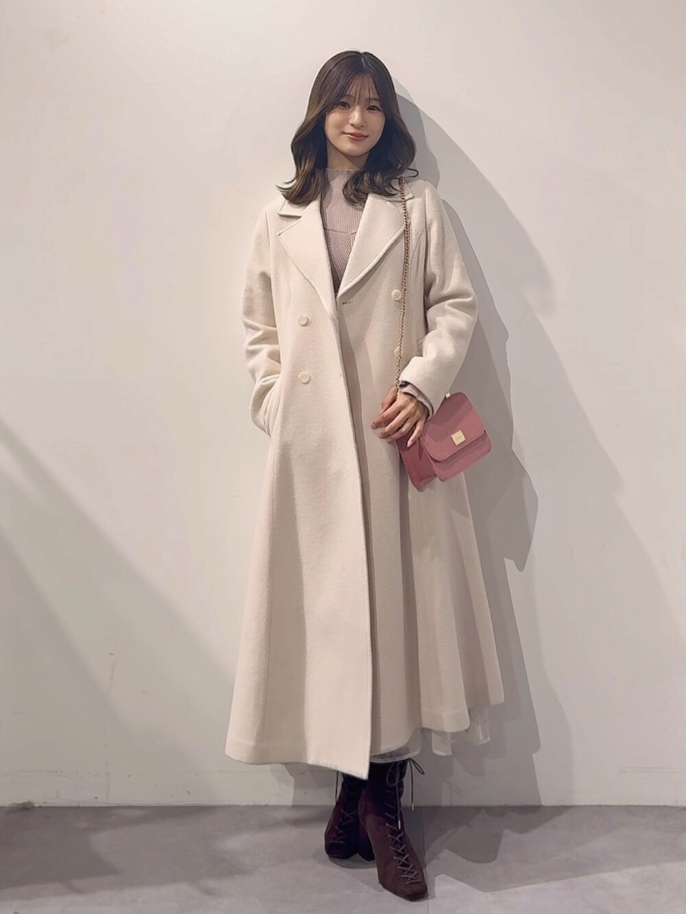 ホワイト系のその他アウター、ピンク系のハンドバッグ、ブラウン系のブーツを着用したレディースの秋コーディネートの8枚目の写真