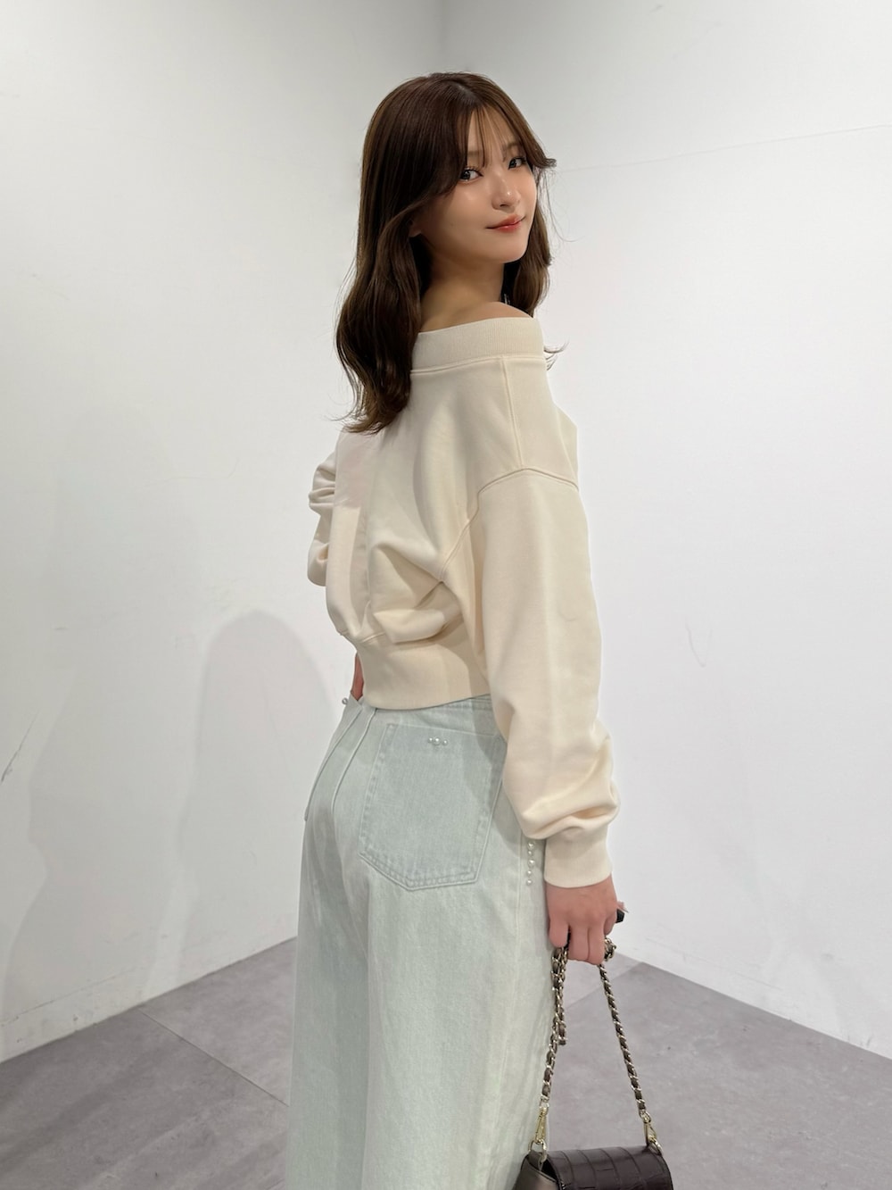 ブラウン系のパンプス、ブルー系のデニムパンツ、ブラウン系のハンドバッグを着用したレディースの春コーディネートの3枚目の写真