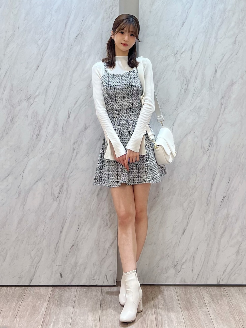 ホワイト系のニット/セーター、ブラック系のシャツ/ブラウス、ブラック系のスカートを着用したレディースの冬コーディネートの3枚目の写真