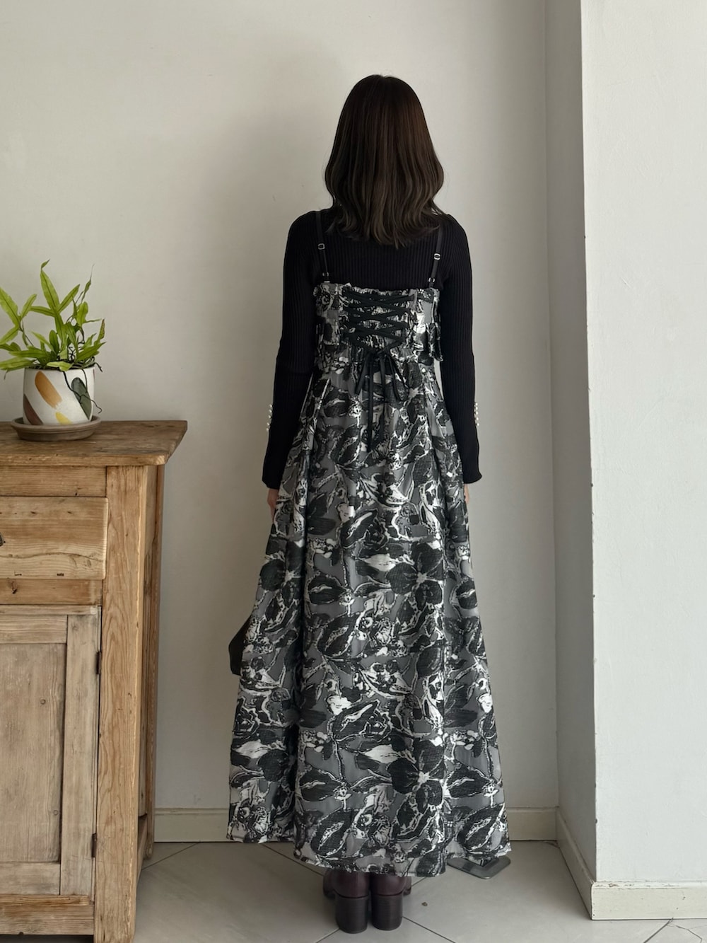 ブラック系のニット/セーター、ブラック系のワンピース、レッド系のブーツを着用したレディースの秋コーディネートの4枚目の写真