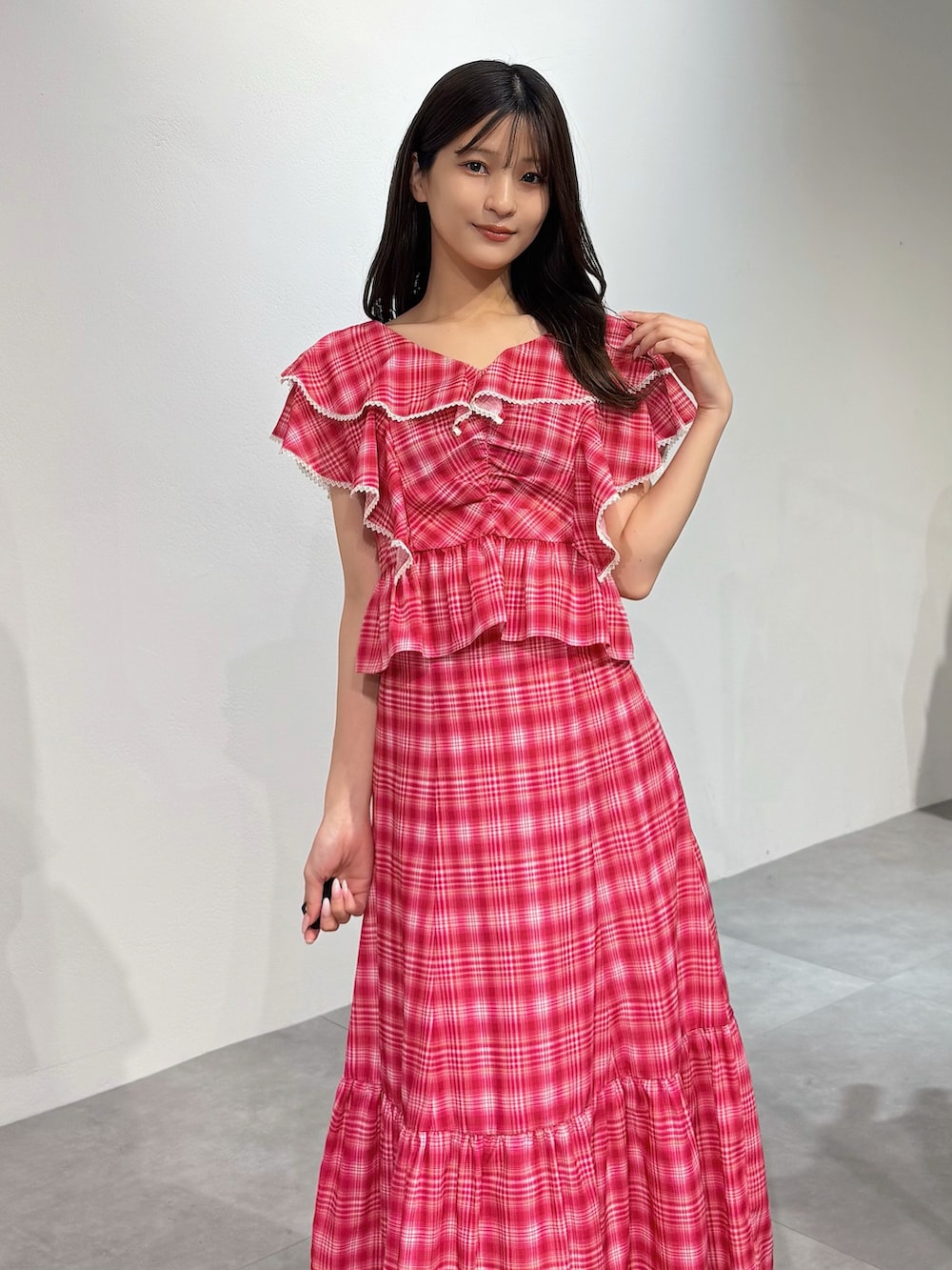 レッド系のスカート、レッド系のシャツ/ブラウス、シルバー系のパンプスを着用したレディースの春コーディネートの2枚目の写真